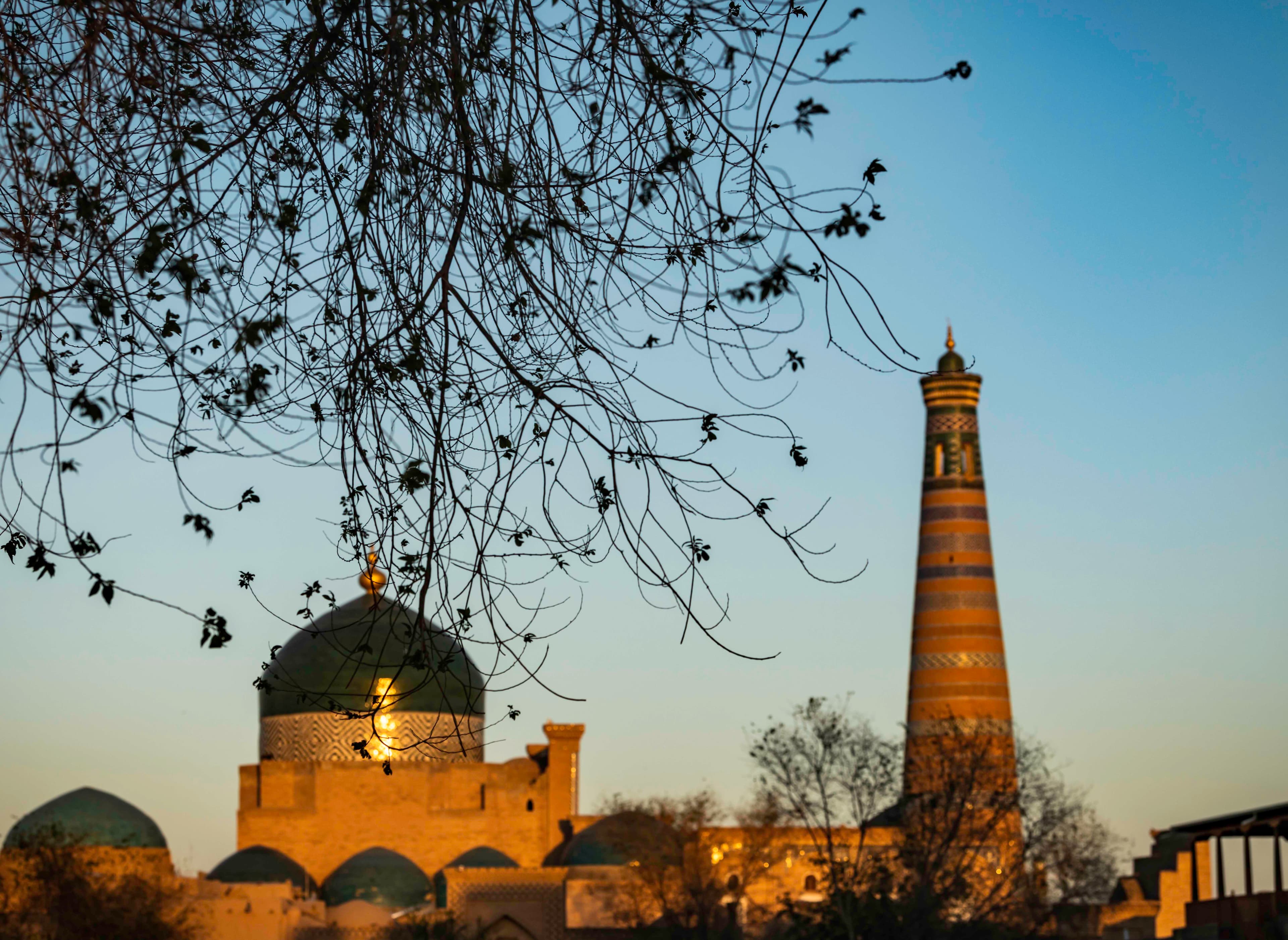 Sunset over ancient minaret and domes, Khiva