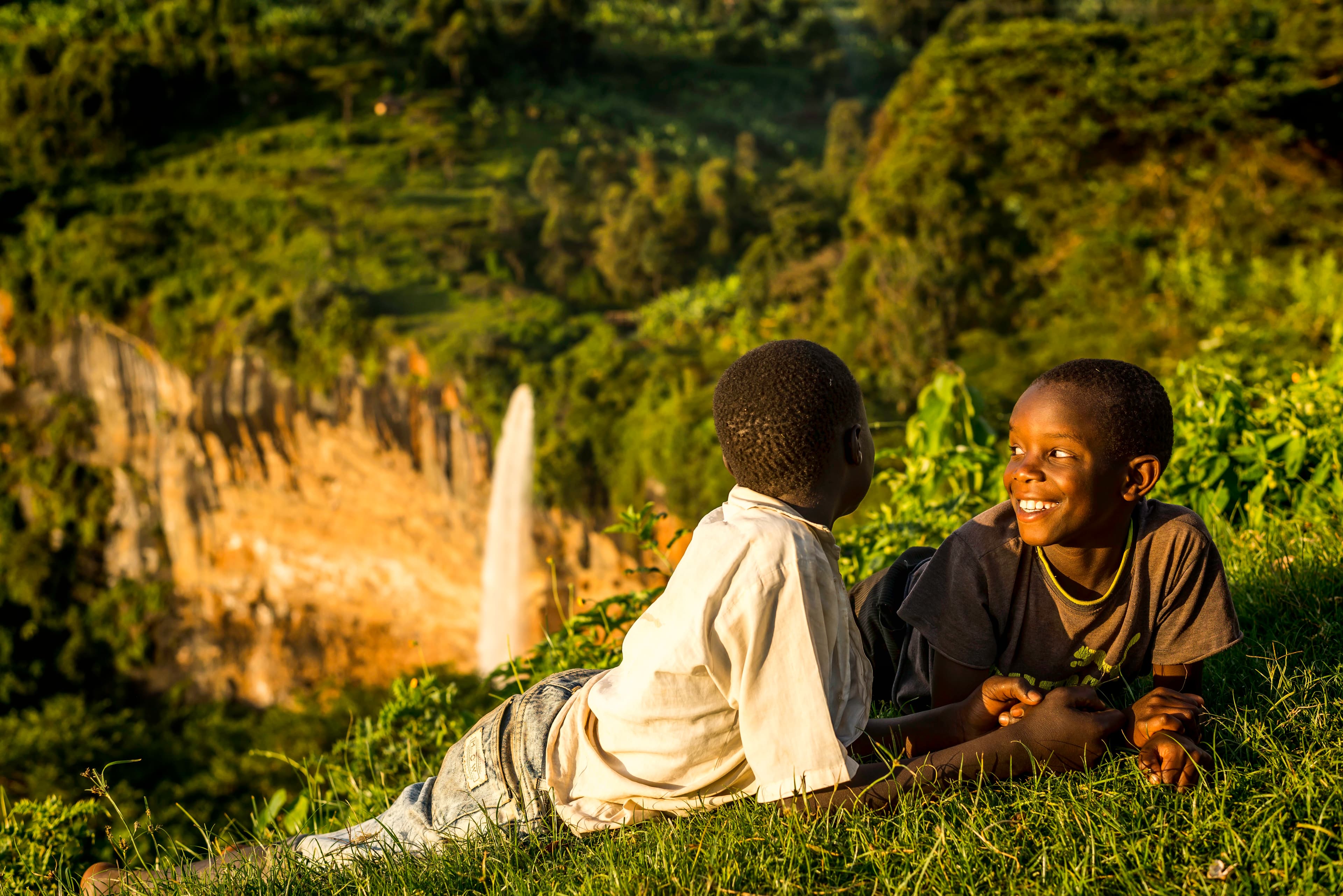 Children laughing by a waterfall, Mount Elgon